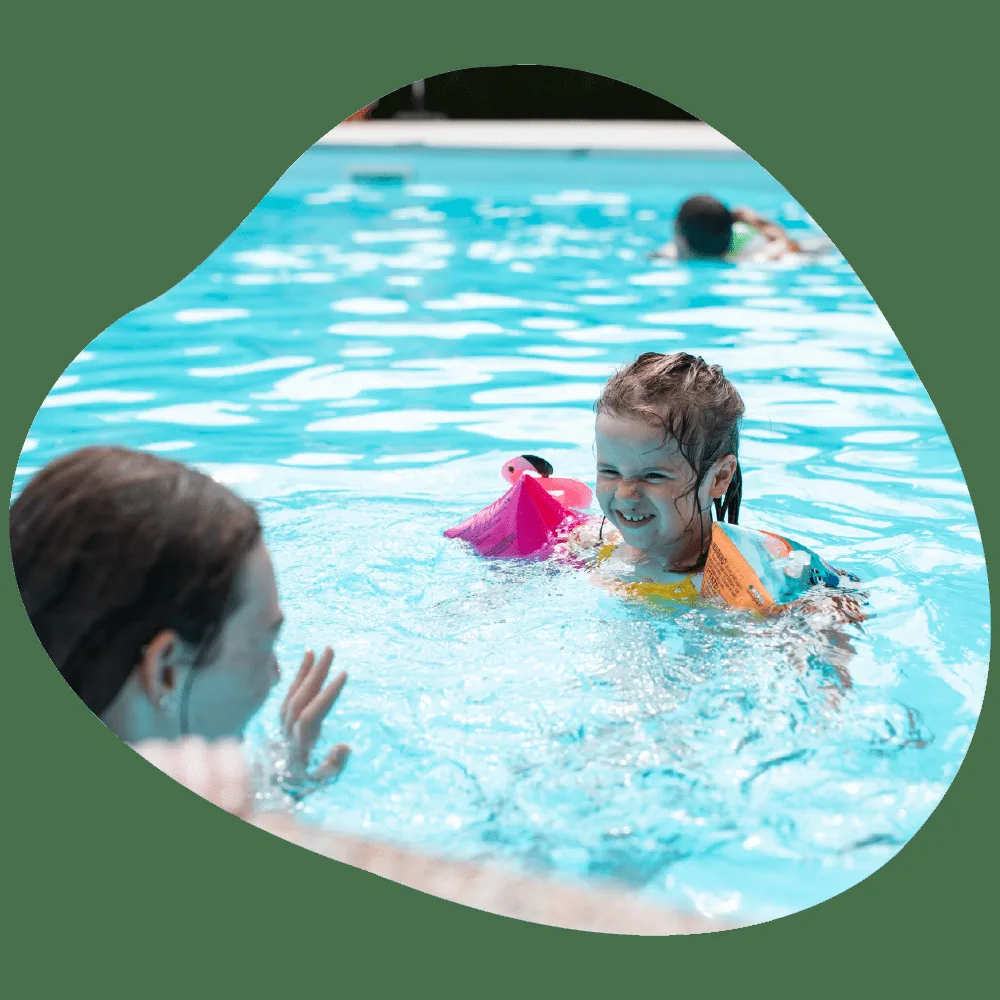 Enfants et parents dans la piscine extérieur du camping à Ispagnac